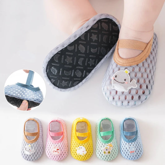 Baby shoes with cartoon shark design and additional pairs in different colors on a light background.