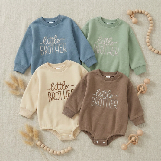 Flat lay collection of four embroidered Little Brother baby boy rompers in blue, sage green, cream, and cocoa colors.