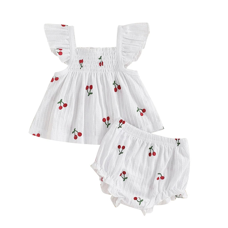 Newborn baby girl 2-piece summer set in white with red cherry embroidery, featuring a smocked bodice, ruffled sleeves, and elastic waist bloomers.