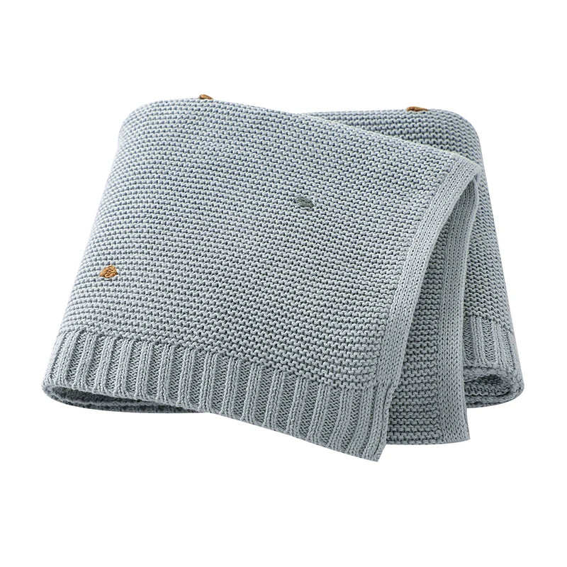 Soft 100% cotton knitted baby blanket in Cloud Blue featuring a textured popcorn dot pattern and ribbed edges.