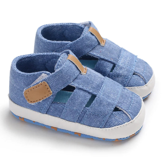 A pair of breathable light blue baby canvas summer sandals with tan accents on a white background.