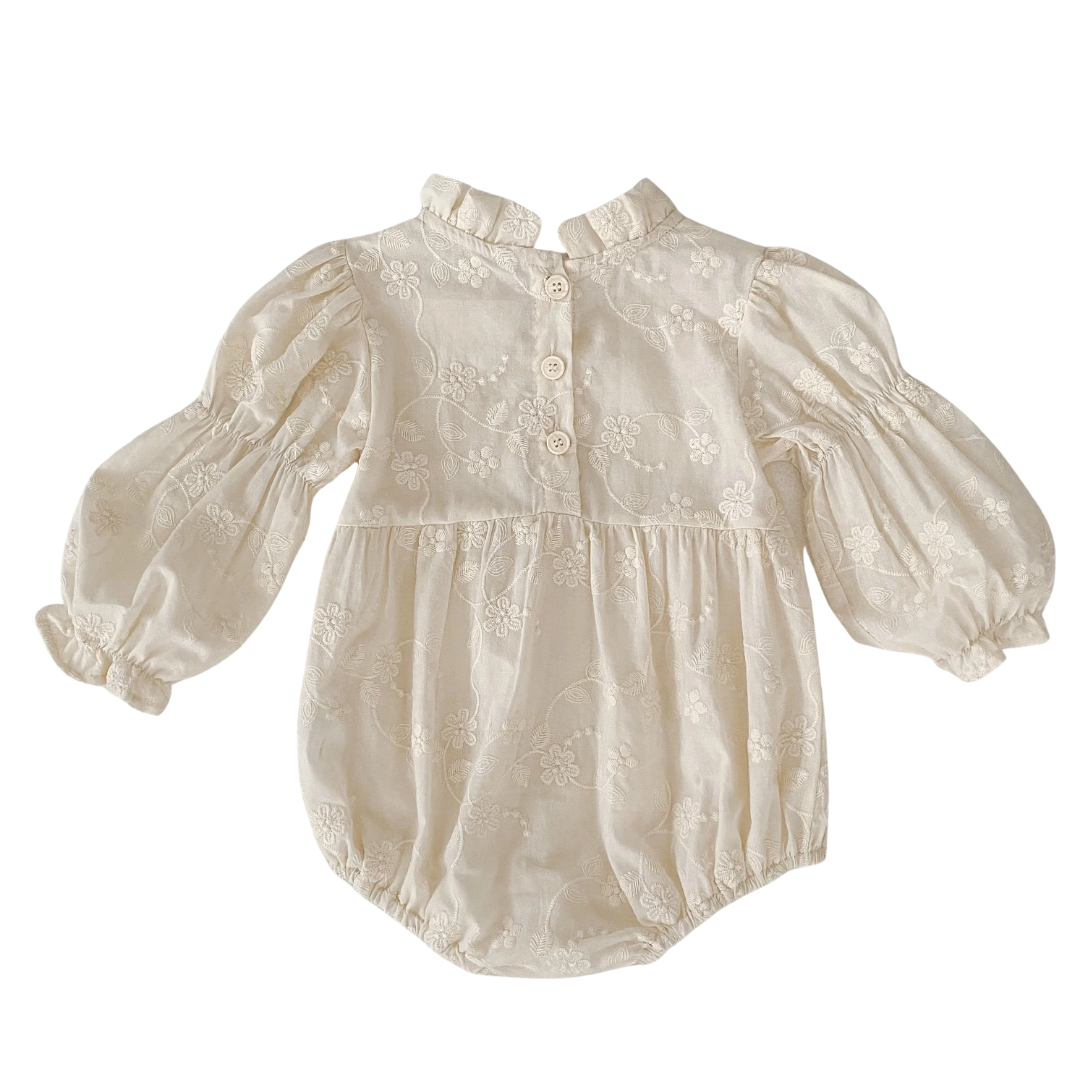 Back view of baby girl ivory floral embroidered bubble romper showing back button closure and high collar.