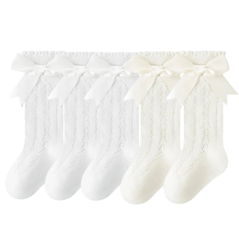 5-pack of baby and toddler girl knee high socks in a solid white and cream mix with matching silky bows.