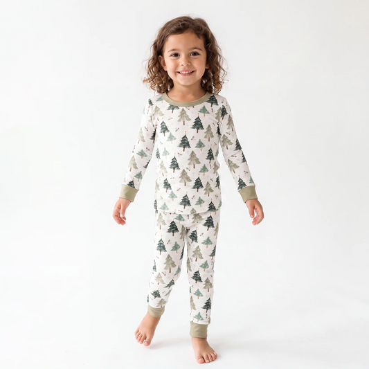 Toddler girl model standing wearing Kidsely Evergreen Christmas Trees bamboo viscose two-piece pajama set