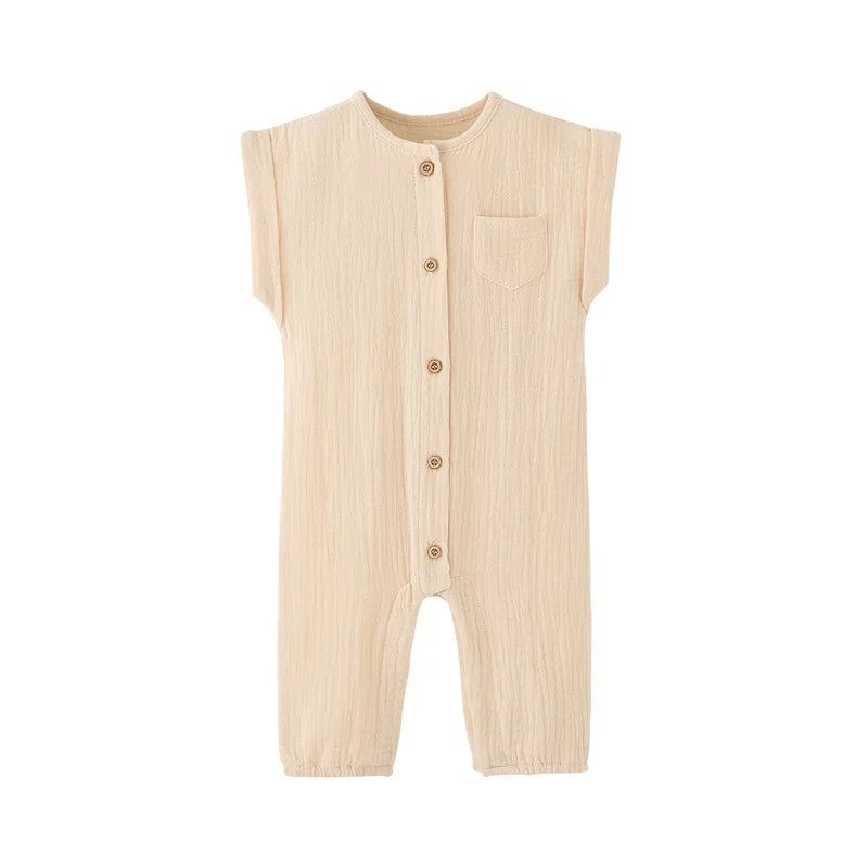 Front view of the vintage-inspired infant jumpsuit in a neutral cream beige, featuring a rolled cap sleeve and rustic buttons.
