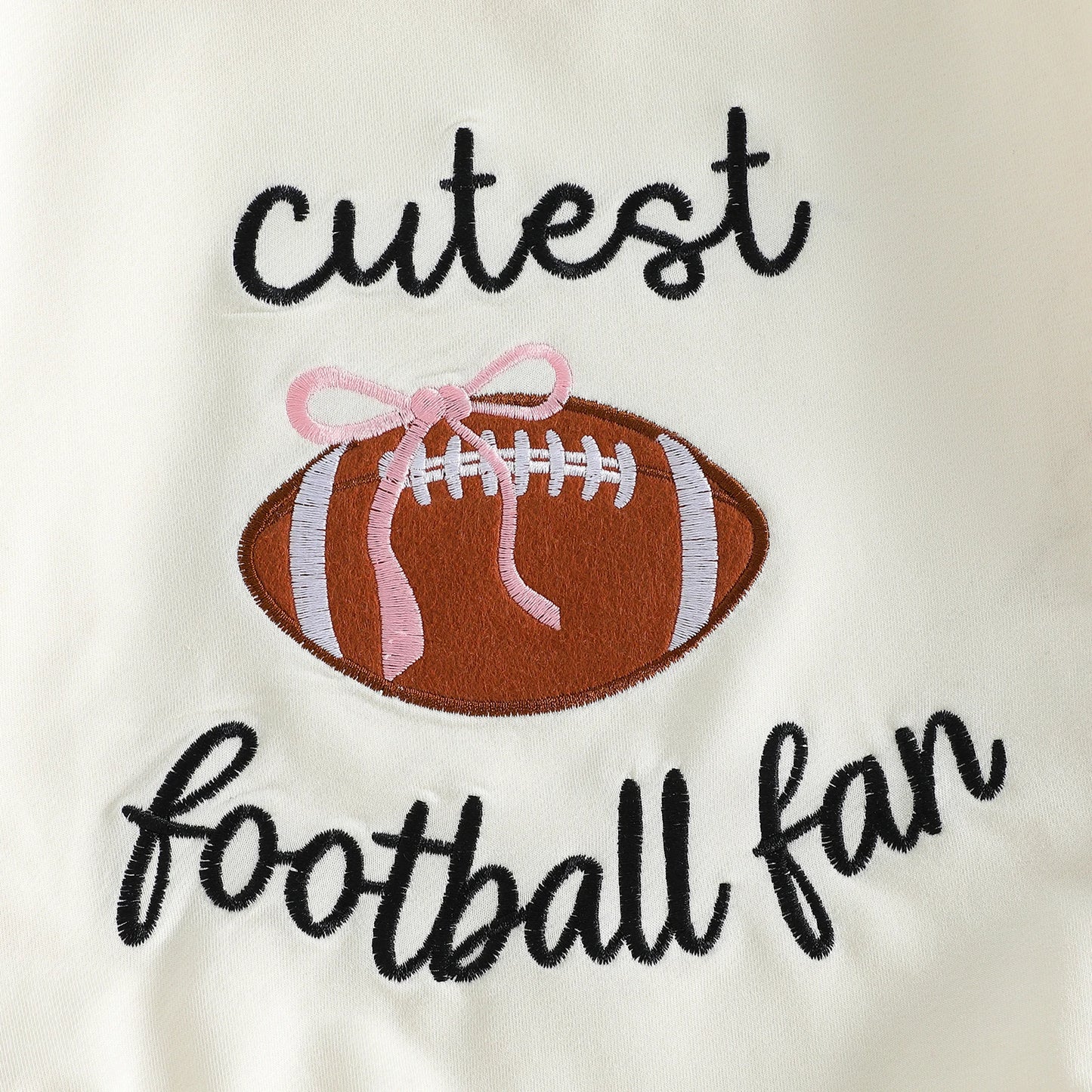 Close-up detail of the "cutest football fan" high-quality embroidery featuring a brown football and delicate pink bow.