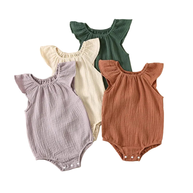 Four premium baby girl muslin rompers stacked together showing wild lavender, oatmeal milk, juniper pine, and terracotta colors.