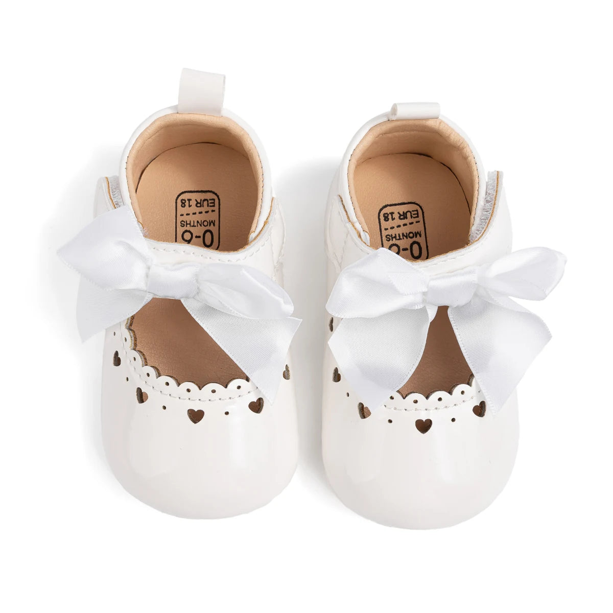 Top-down view of white infant Mary Jane shoes showing the inner lining and structural design.