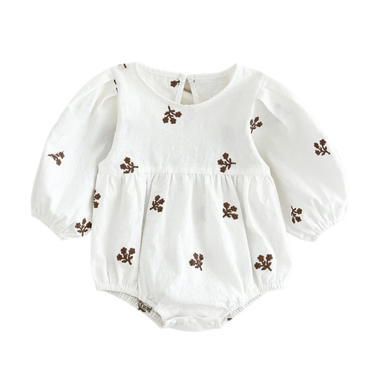 Flat lay of a white long-sleeve cotton baby romper featuring brown floral embroidery.