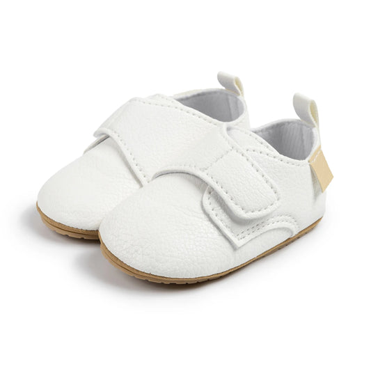 Pair of white toddler velcro loafers made of soft faux leather with an adjustable strap.
