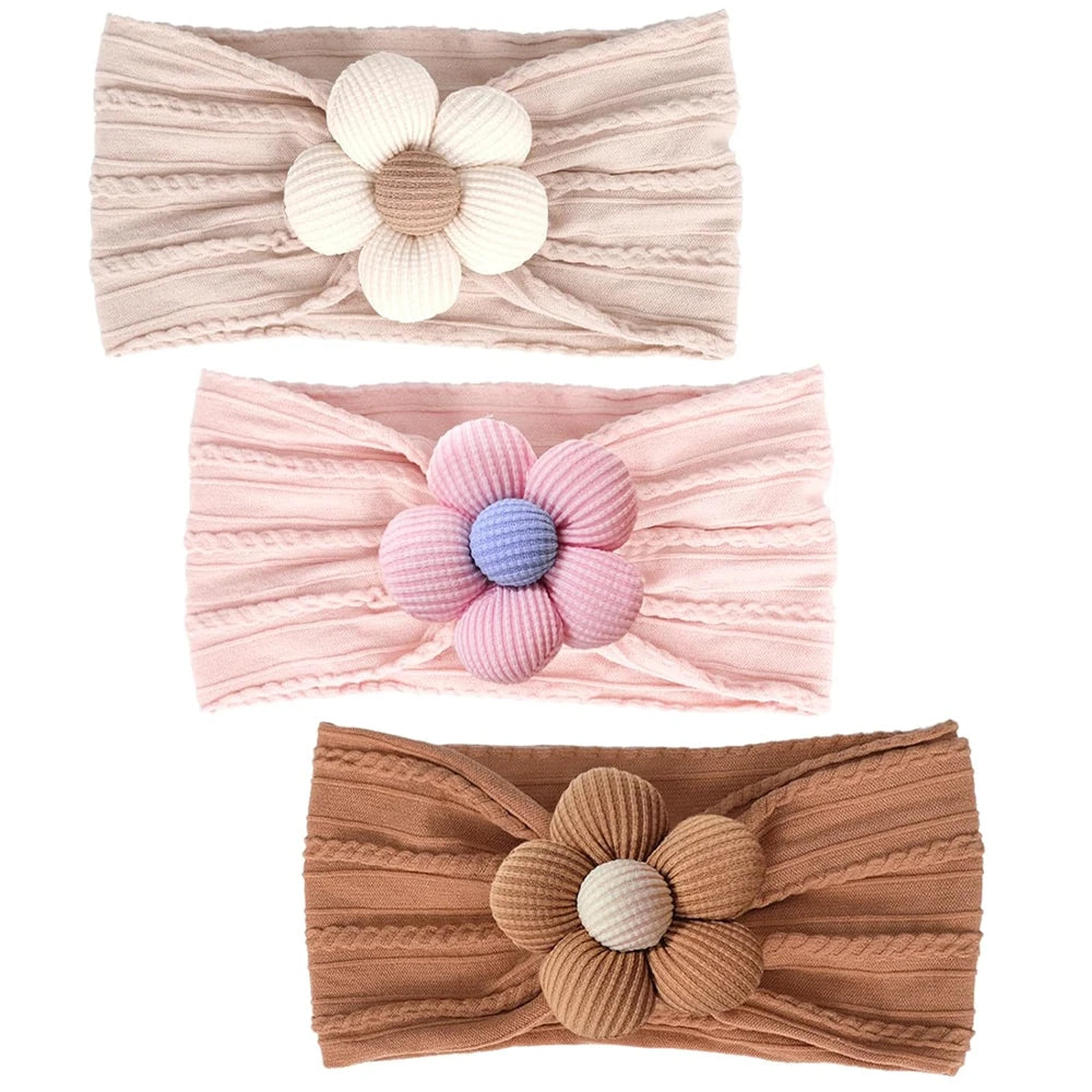 three-pack of baby nylon headbands featuring oat, caramel, and petal pink with a lavender flower center