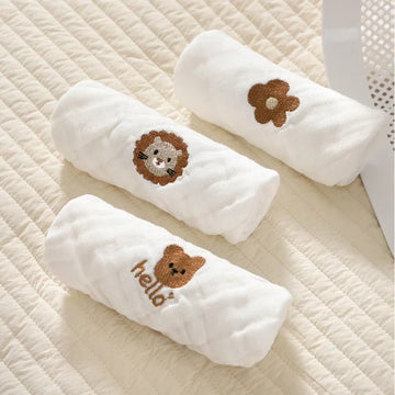 Rolled 6-layer white muslin baby burp cloths featuring cute embroidered lion, bear, and flower designs.