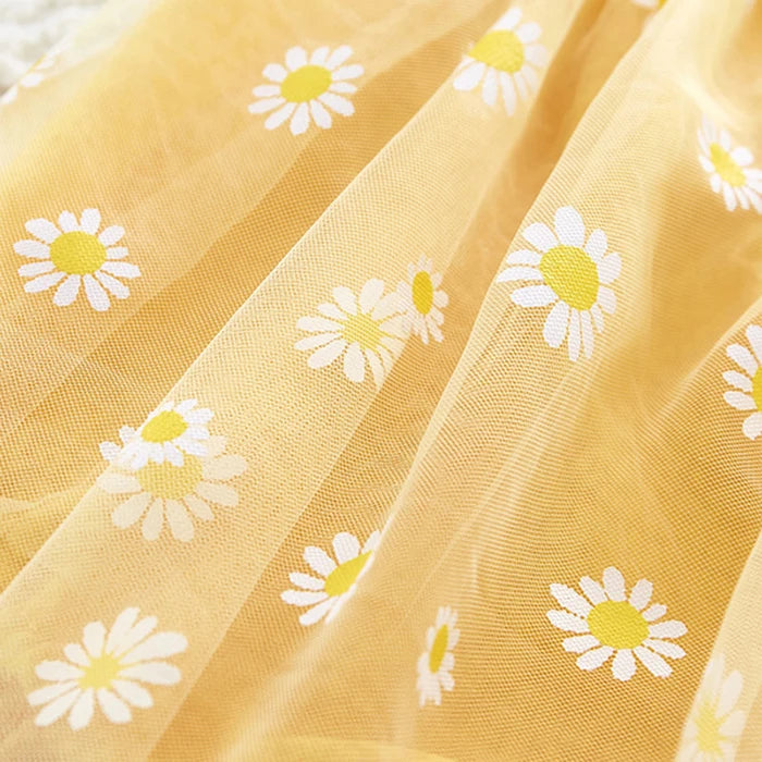 Close-up of yellow fabric with white daisy patterns