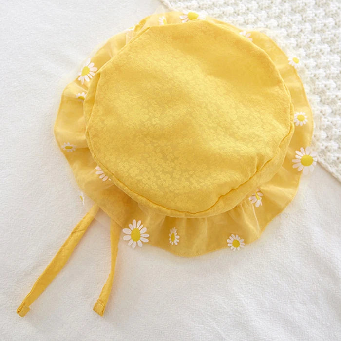 Yellow baby sun hat with floral details on a white background