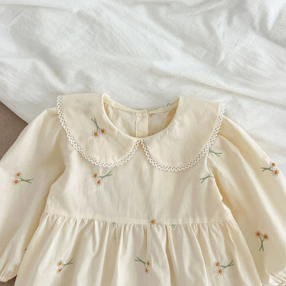 Cream-colored dress with floral embroidery on a white background