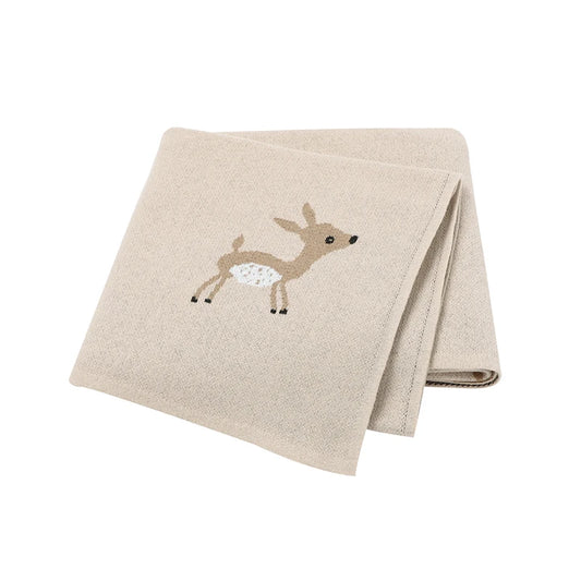 A beige cotton knit blanket with a cute sika deer design, folded and displayed on a flat surface.