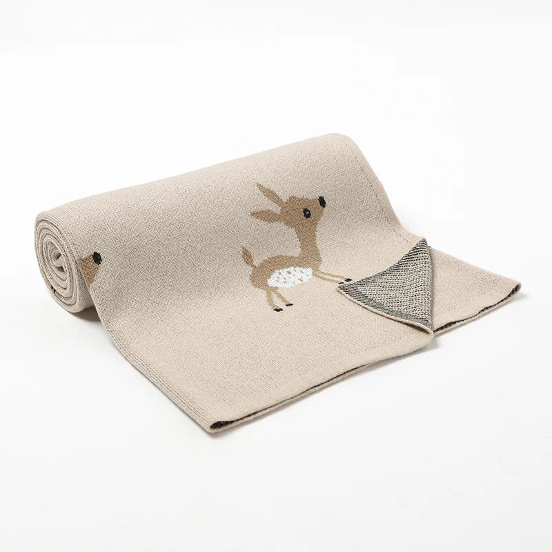A beige cotton knit blanket with a cute sika deer design
