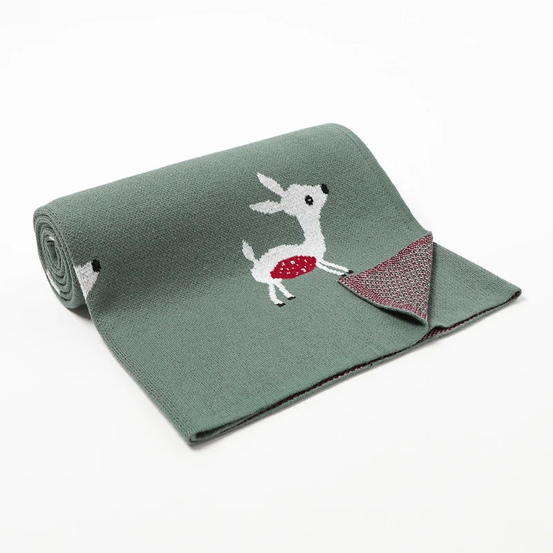 A green cotton knit blanket with a cute sika deer design