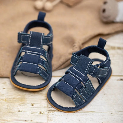 Navy blue infant summer sandals for baby boys, showing the breathable fabric upper and adjustable hook-and-loop velcro strap for a secure fit.