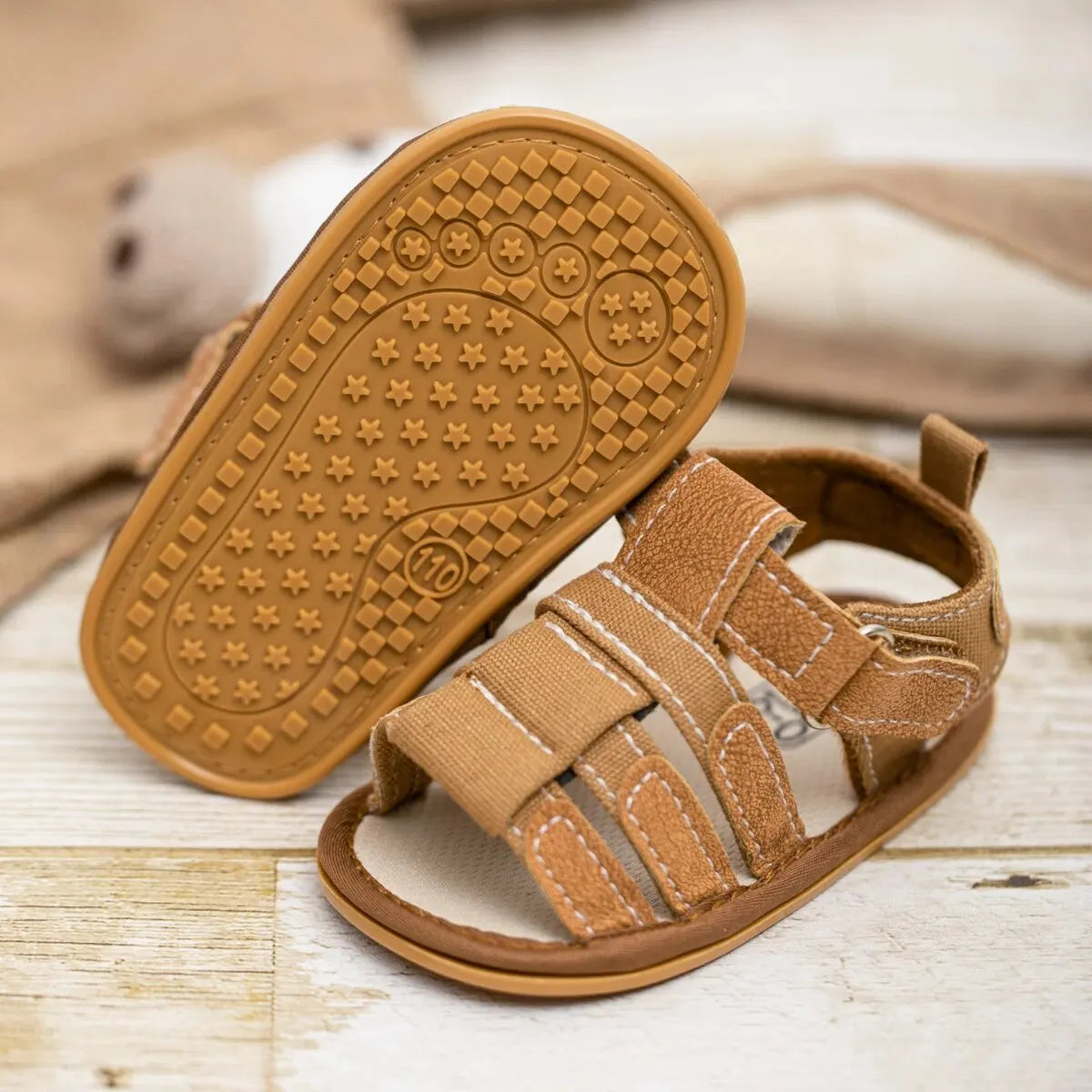 Close-up of the anti-slippery rubber outsole on a baby boy sandal, featuring a star-patterned grip for traction and stability during first steps.