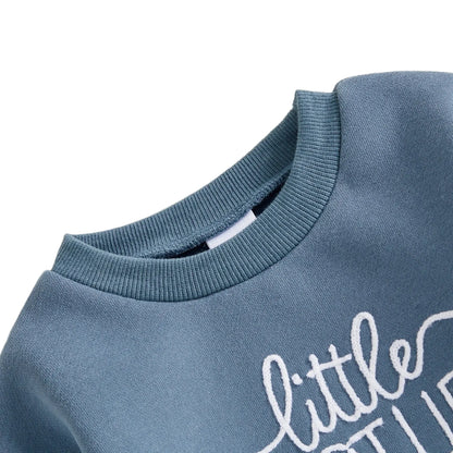 Close-up detail of the ribbed crewneck collar and white embroidery on the blue fleece baby romper.