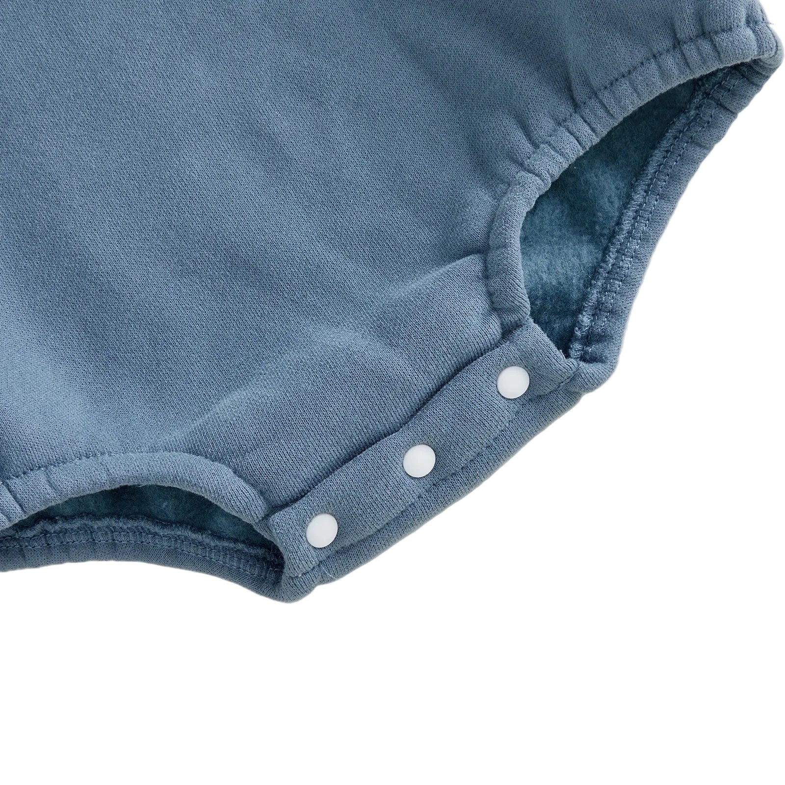 Close-up view of the three white bottom snap button closures for easy diaper changes on the blue fleece romper.