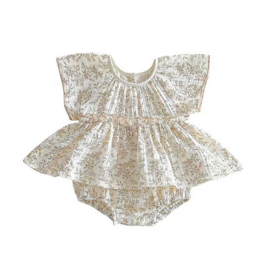 Flat lay view of a two-piece baby outfit set made from cream crinkle muslin fabric with a delicate brown floral pattern. The set includes a ruffled flutter-sleeve peplum top and matching bloomers.