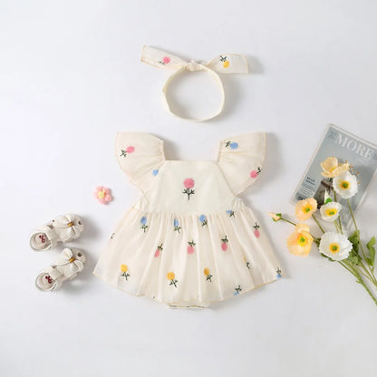 Two-piece baby girl summer clothing set including a white floral embroidered romper dress and a coordinating pink floral print knotted headband.