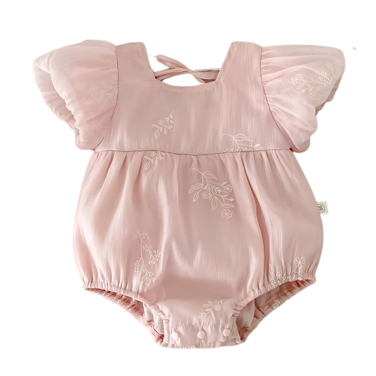 Flat lay of a dusty pink baby girl cotton romper featuring white floral embroidery, sheer bubble sleeves, and a back-tie ribbon on a white background.