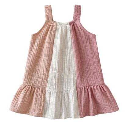 flat lay view of baby girl sleeveless tiered muslin sundress featuring three vertical colorblock panels in blush pink, white, and dusty rose cotton gauze