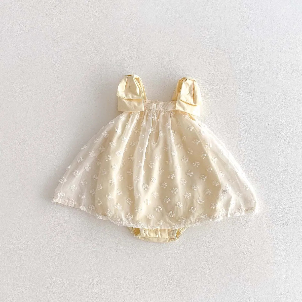 Yellow Baby dress with bow straps on a white background