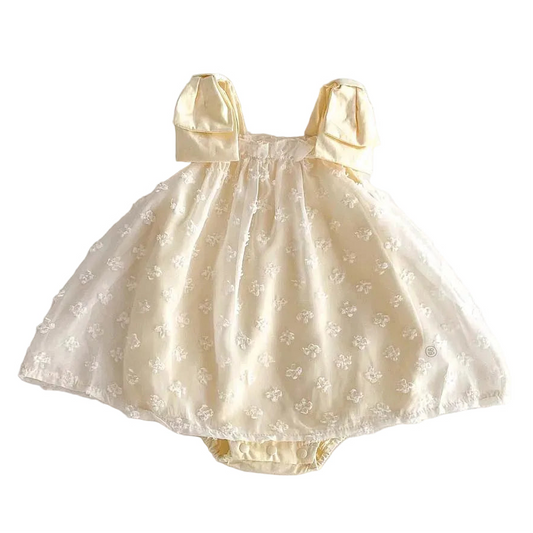 Yellow Baby dress with bow straps on a white background