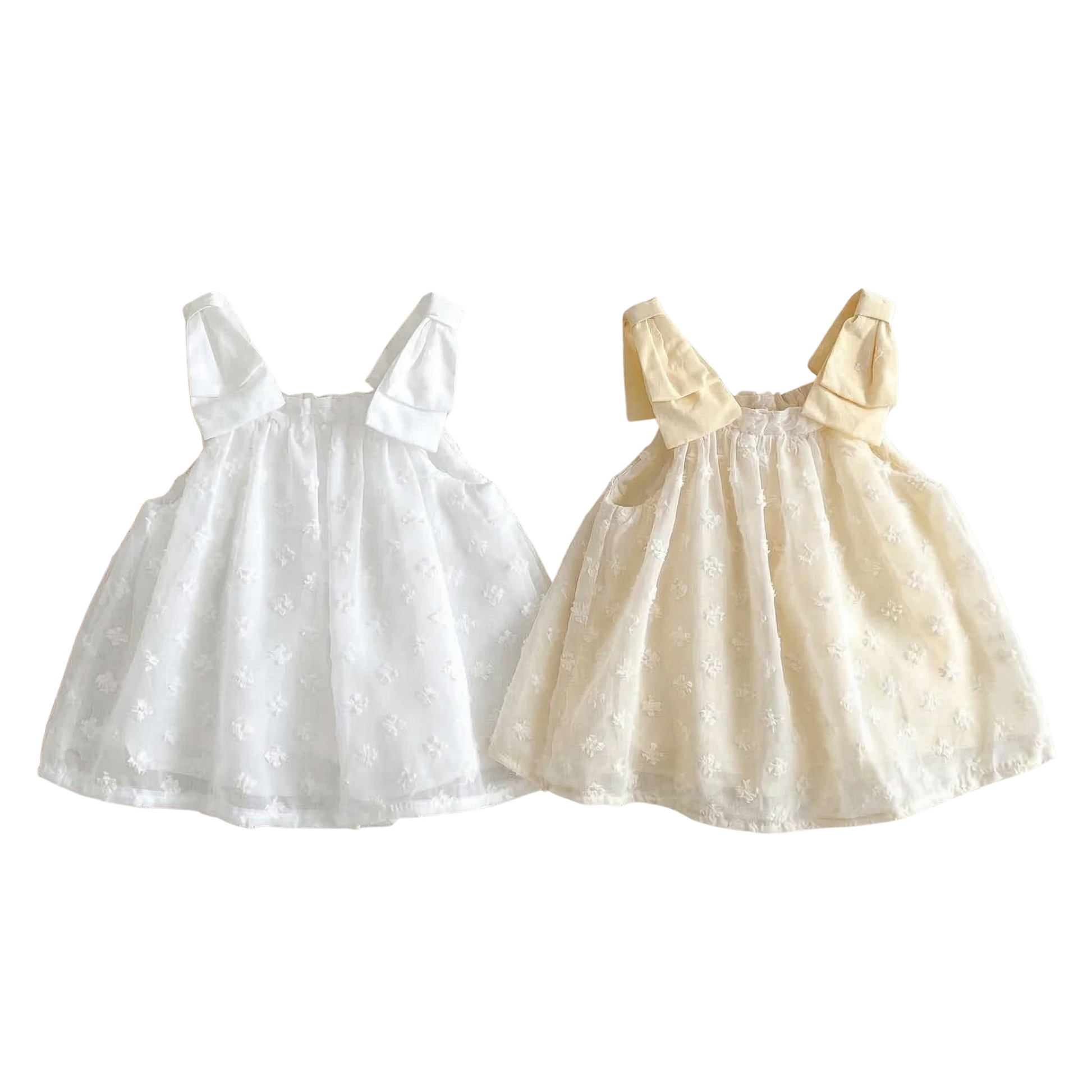 Two children's dresses, one white with 3D Swiss Dot floral pattern dots and the other beige with a bow, on a white background.