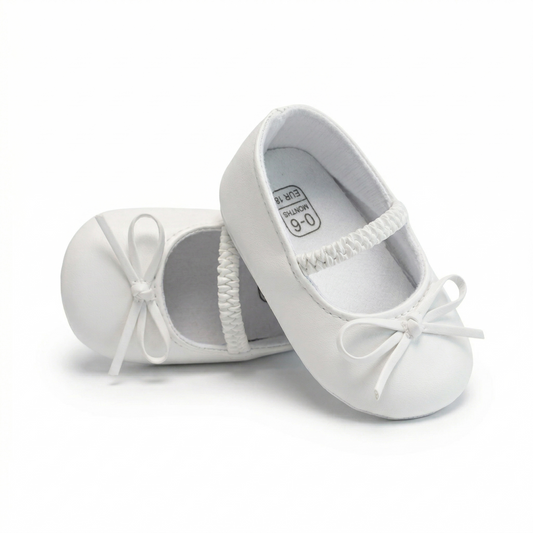 Front view of a pair of white baby girl ballet flats with a butterfly-knot bow and elastic Mary Jane strap on a clean white background.