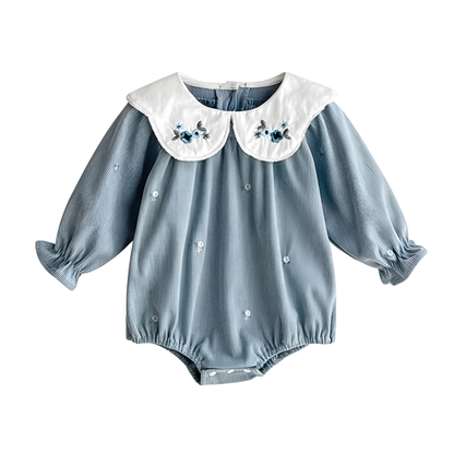Flat lay of a cottagecore vintage style light blue corduroy baby romper with white floral embroidered collars.