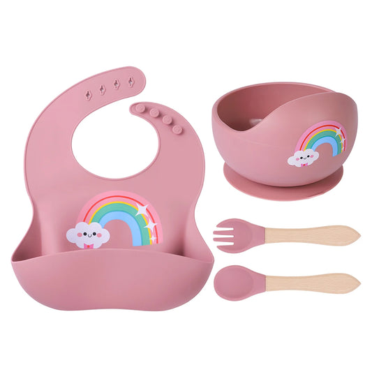 4-piece feeding set arranged flat, featuring a round silicone suction bowl, adjustable bib, and wooden-handled fork and spoon.