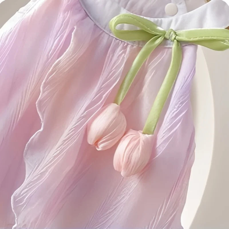 Pink dress with tulip-shaped flowers and a green ribbon on a light background