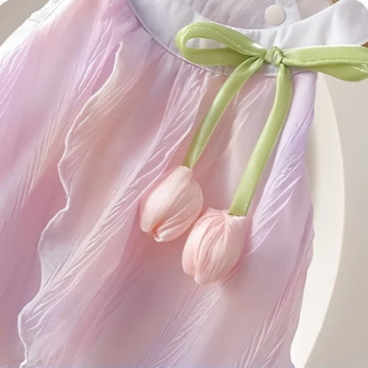 Pink dress with tulip-shaped flowers and a green ribbon on a light background