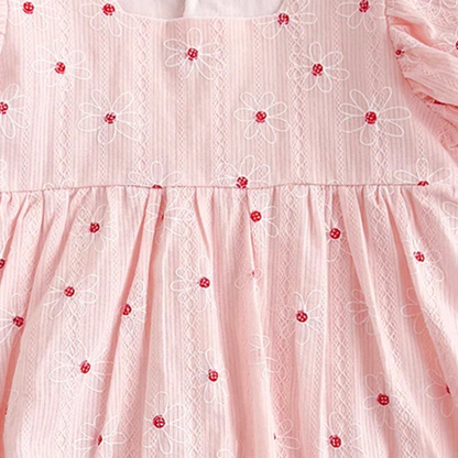 Close-up of a pink dress with floral embroidery