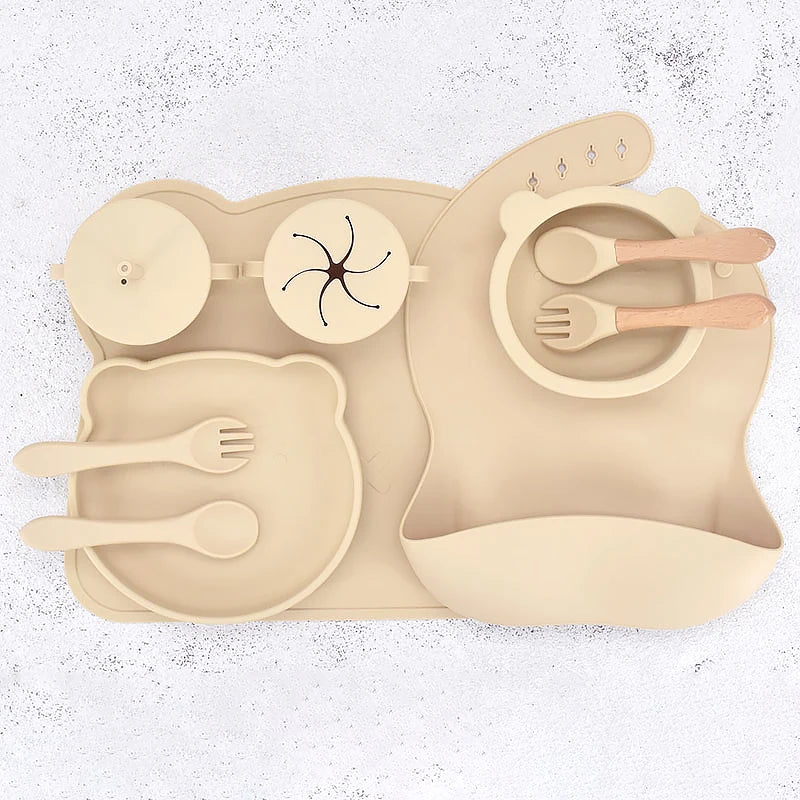 Beige silicone placemat with cutout shapes for utensils on a white background