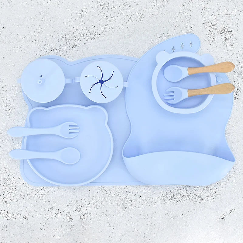 Blue silicone placemat with cutlery on a textured white surface