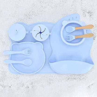 Blue silicone placemat with cutlery on a textured white surface