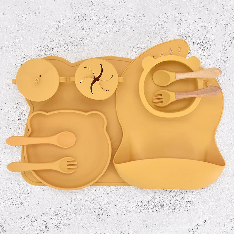Yellow silicone placemat with cutlery on a textured white background