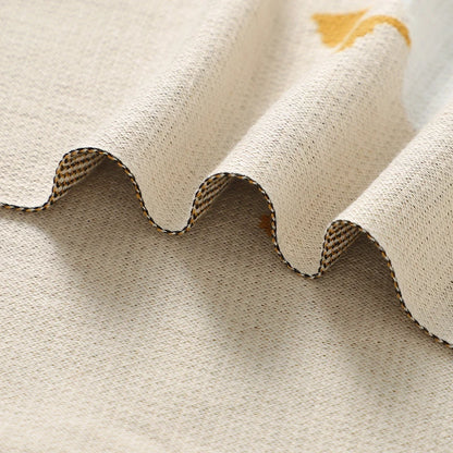 Close-up of textured beige fabric with a scalloped edge