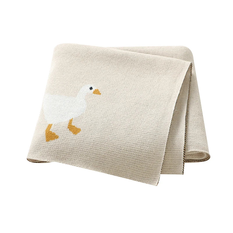 Beige folded blanket with a duck design on a white background