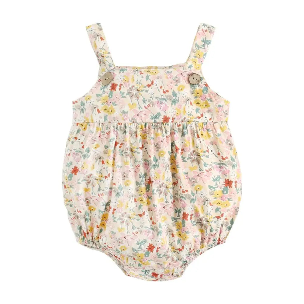 Flat lay view of a cream and yellow floral print cotton baby sunsuit with a bubble silhouette and decorative wood buttons.