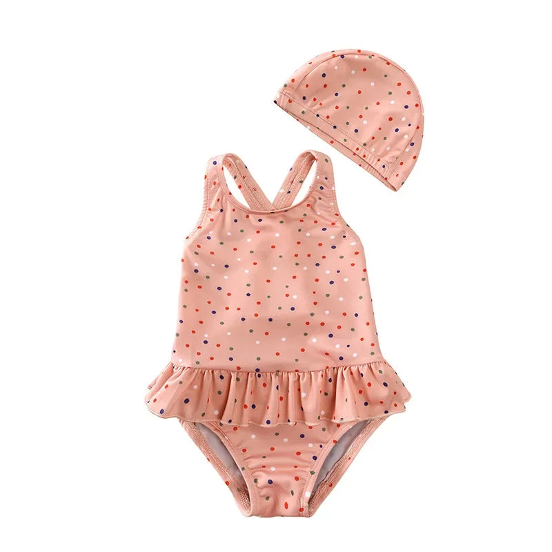 Toddler girl one-piece swimsuit in Desert Rose Confetti with matching swim cap and ruffle skirt.