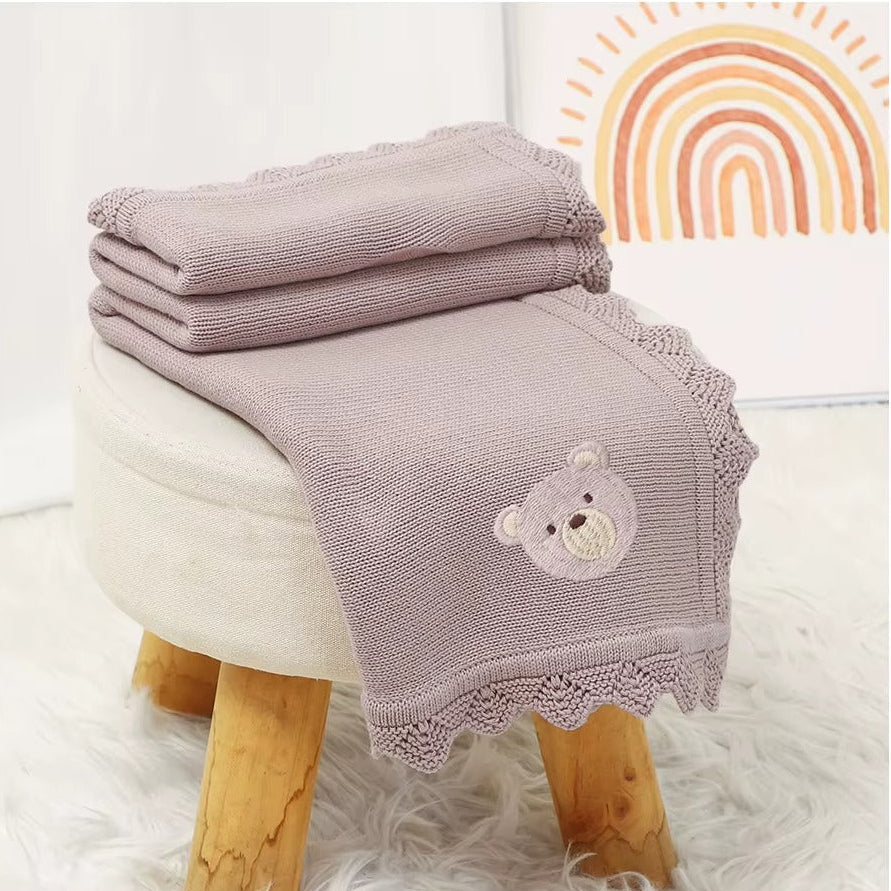 Light purple baby blanket with teddy bear design on a wooden stool, with additional views of the blanket.
