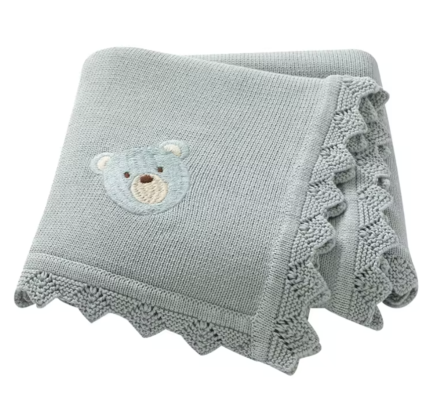 Green knitted blanket with a teddy bear Applique on a white background