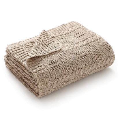 Beige knitted blanket with a subtle pattern on a white background